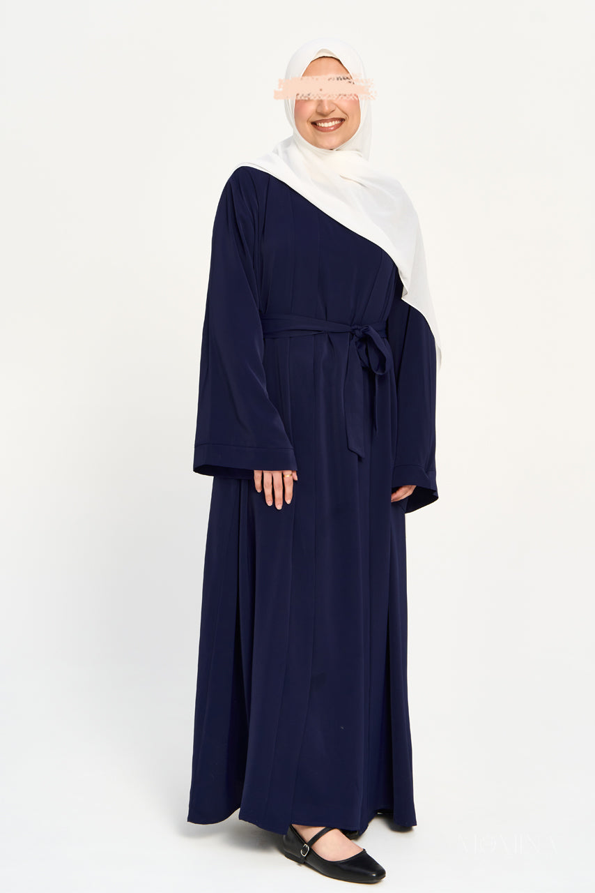Woman wearing a navy blue abaya set tied at the front with a white hijab by Momina Hijabs