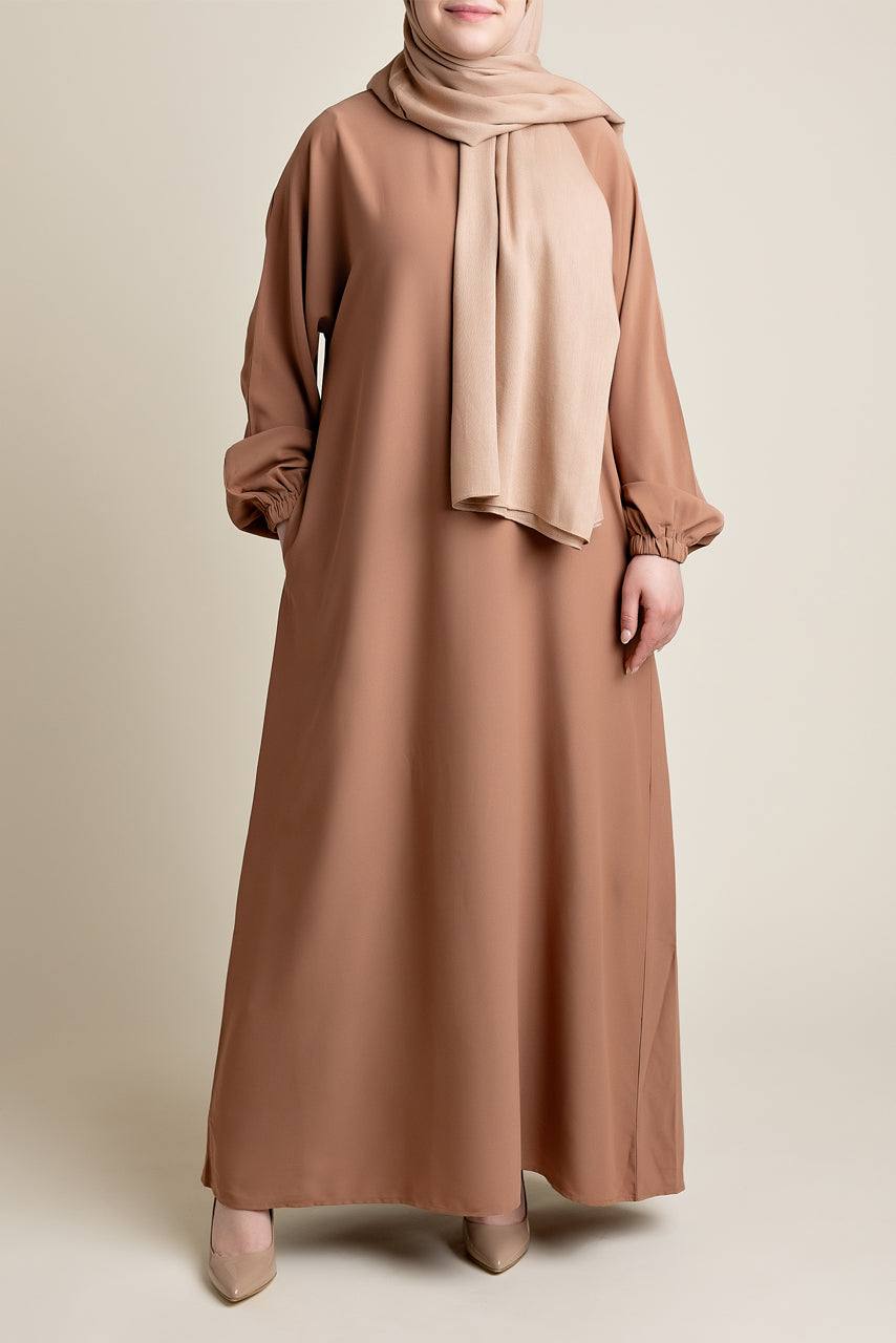 Model wearing a classic Abaya with side pockets in a tan or auburn brown color - Front pose - Momina Hijabs