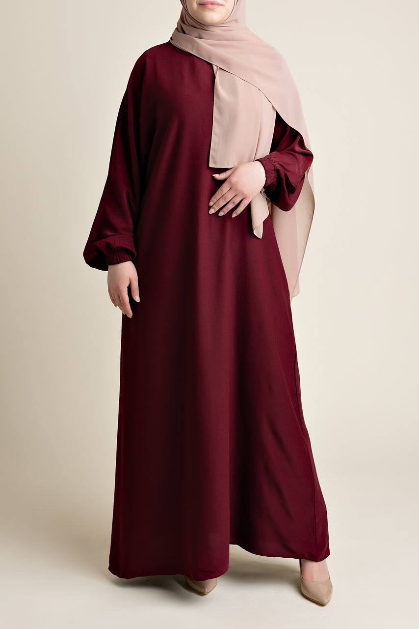 Model wearing a classic Abaya with side pockets in a maroon or dark red color - Front Pose - Momina Hijabs