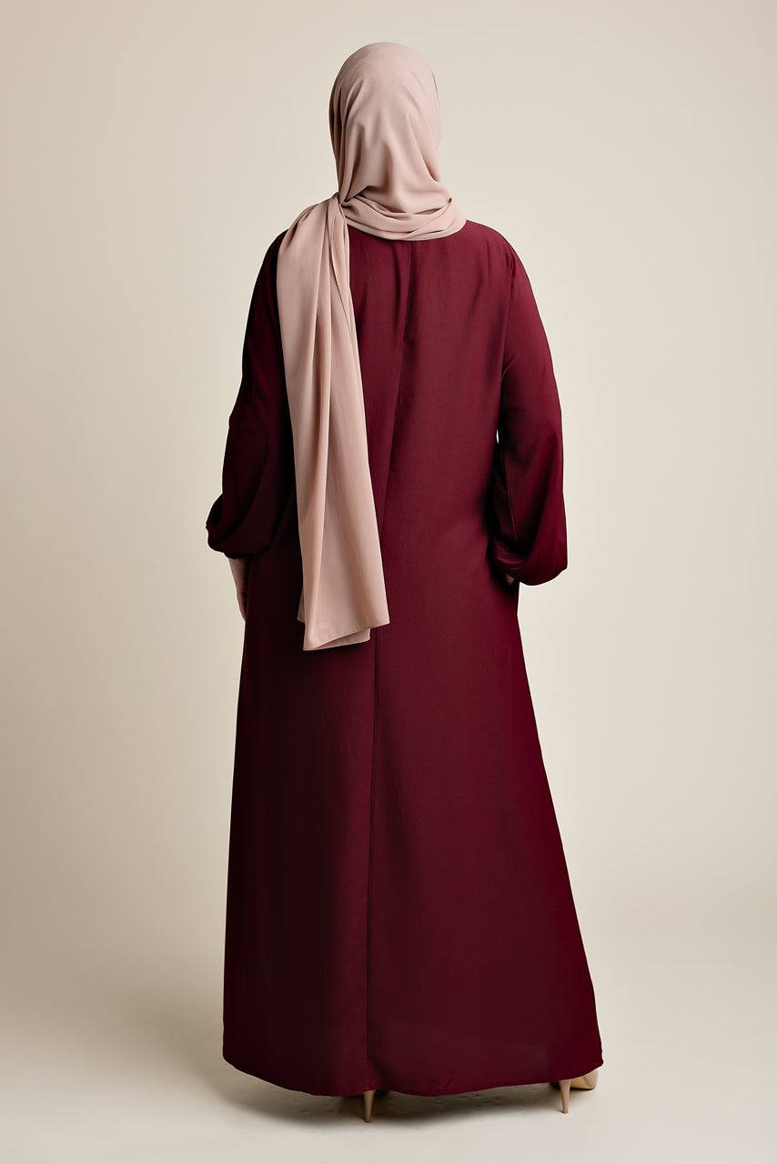 Model wearing a classic Abaya with side pockets in a maroon or dark red color - Rear pose - Momina Hijabs