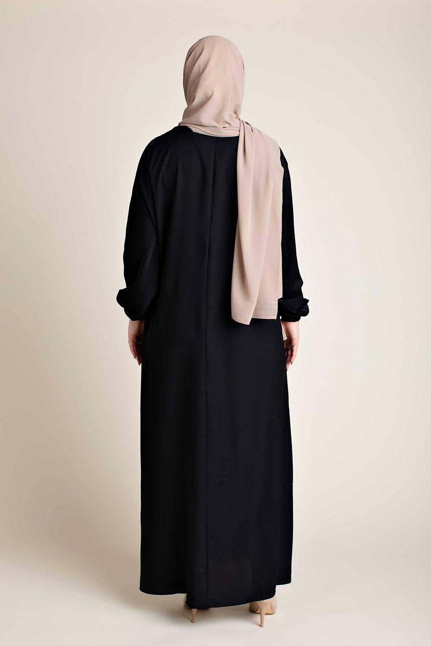 Model wearing a classic Abaya with side pockets in a black color - Rear pose - Momina Hijabs