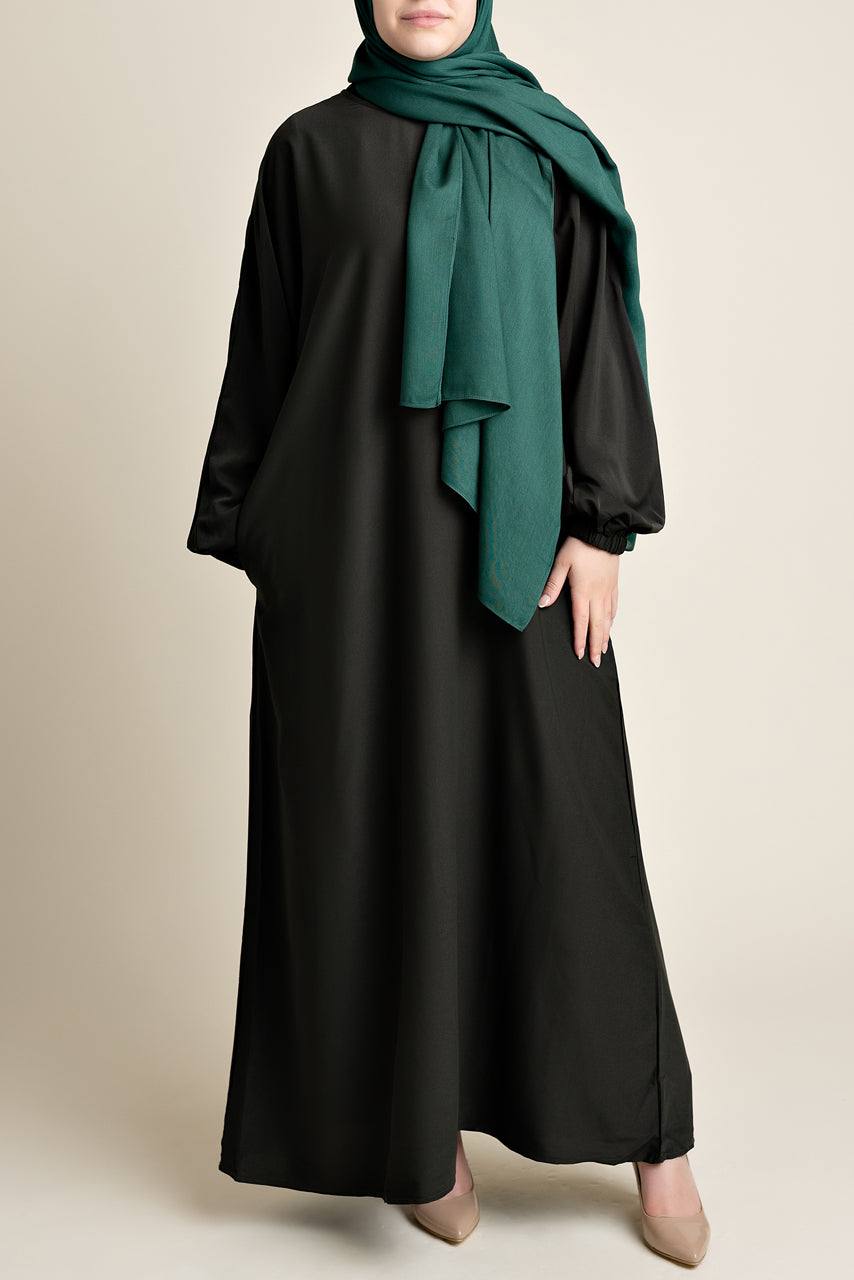 Model wearing a classic Abaya with side pockets in a dark olive green color - Front pose - Momina Hijabs