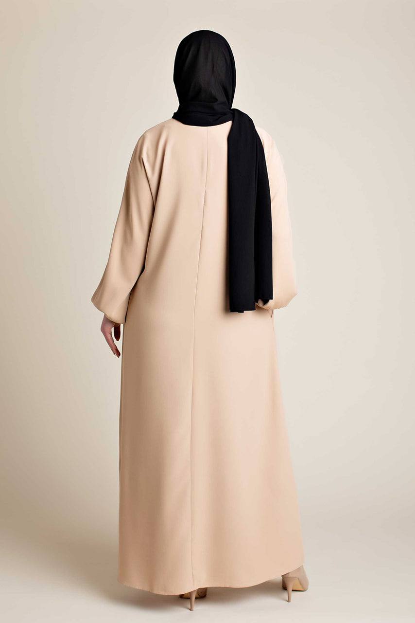 Model wearing a classic Abaya with side pockets in a cream color - Rear pose - Momina Hijabs