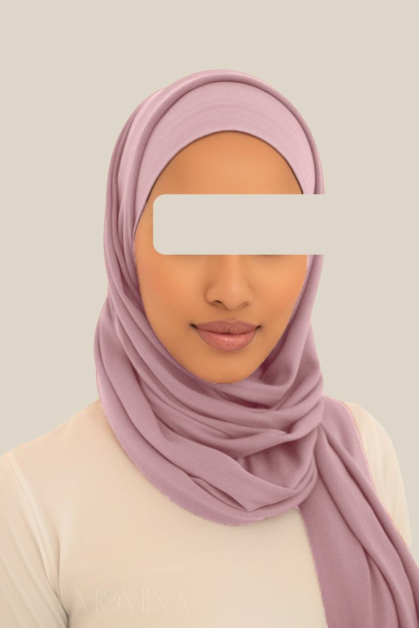 A woman wearing a matching lavender jersey hijab set from Momina Hijabs.