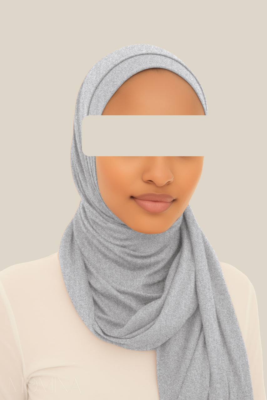 A woman wearing a matching jersey hijab set of a light marble gray hijab by Momina Hijabs.