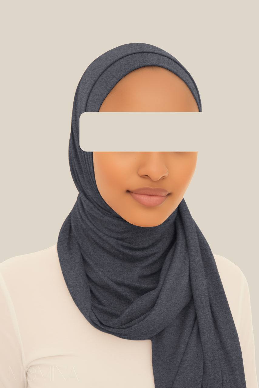 A woman wearing Momina Hijab's matching set of a dark marble gray jersey hijab and tube undercap.